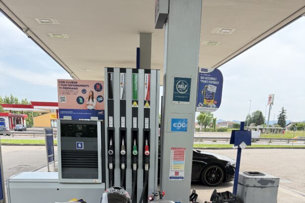 Moto sportiva parcheggiata a un distributore di benzina Q8, con casco sul sellino